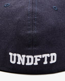 UNDEFEATED HO25 X NEW ERA ALL OVER FITTED - NAVY