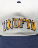 UNDEFEATED 2 TONE ARCH SNAPBACK IVORY NAVY