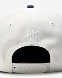 UNDEFEATED 2 TONE ARCH SNAPBACK IVORY NAVY