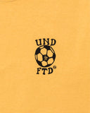 UNDEFEATED FUTBOL S/S TEE MARIGOLD