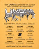 UNDEFEATED TEAM STORE S/S TEE MARIGOLD
