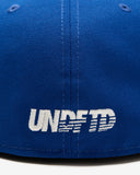 UNDEFEATED SU26 X NE ICON CREST FITTED - BLUE