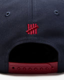 UNDEFEATED SP26 PLAY DIRTY SNAPBACK - NAVY