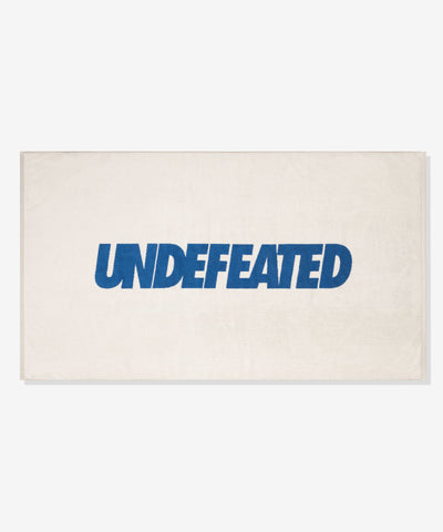 UNDEFEATED SU26 LOGO BEACH TOWEL- CREAM