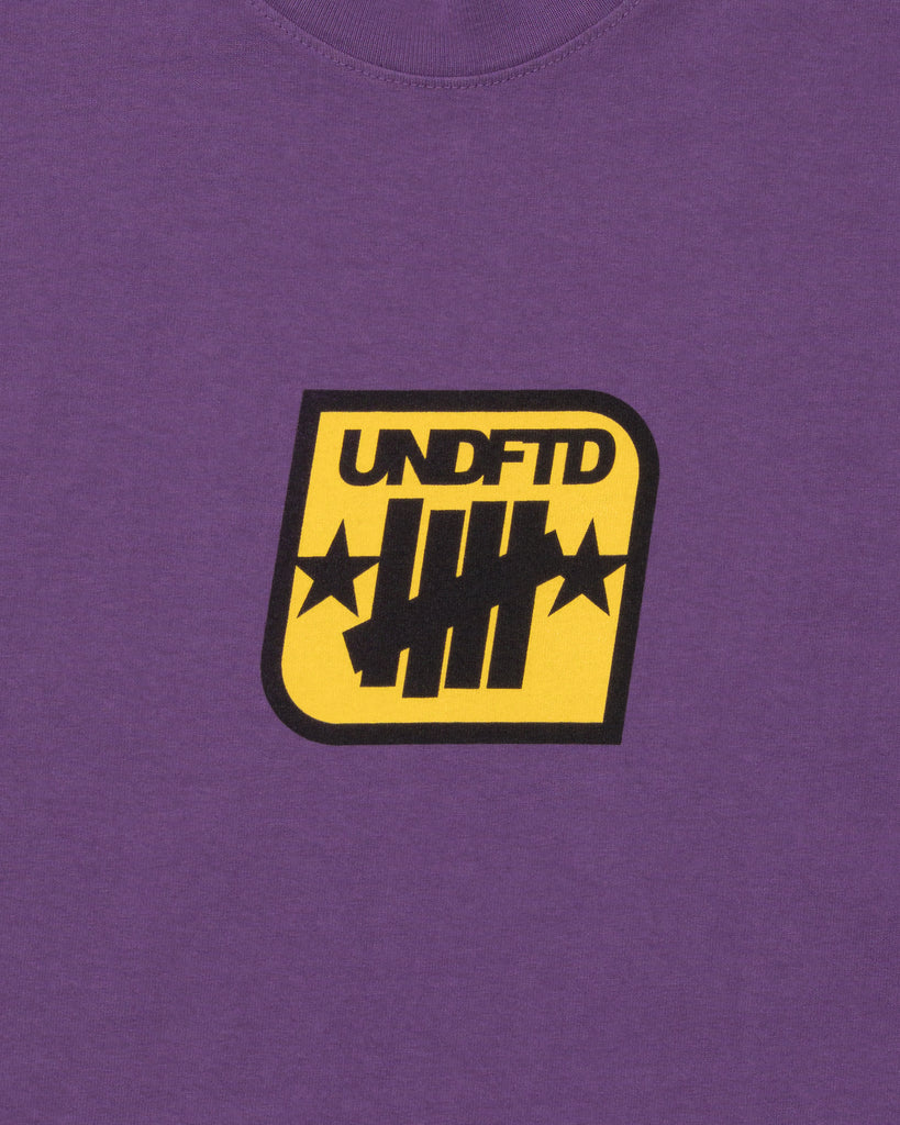 SU26 UNDEFEATED BADGE S/S TEE - PURPLE