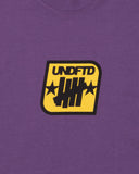 SU26 UNDEFEATED BADGE S/S TEE - PURPLE