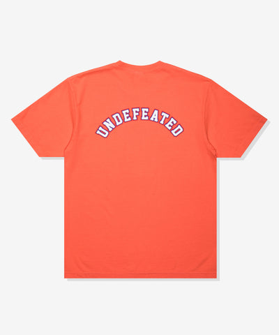 UNDEFEATED SP26 EMBLEM S/S TEE-CORAL