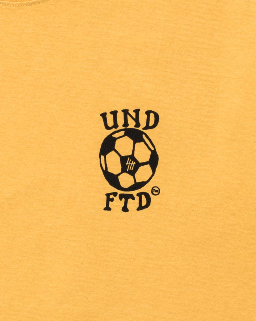 UNDEFEATED FUTBOL S/S TEE MARIGOLD